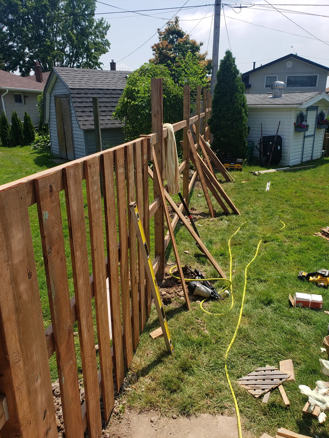 Cedar pickets being installed during a fence replacement