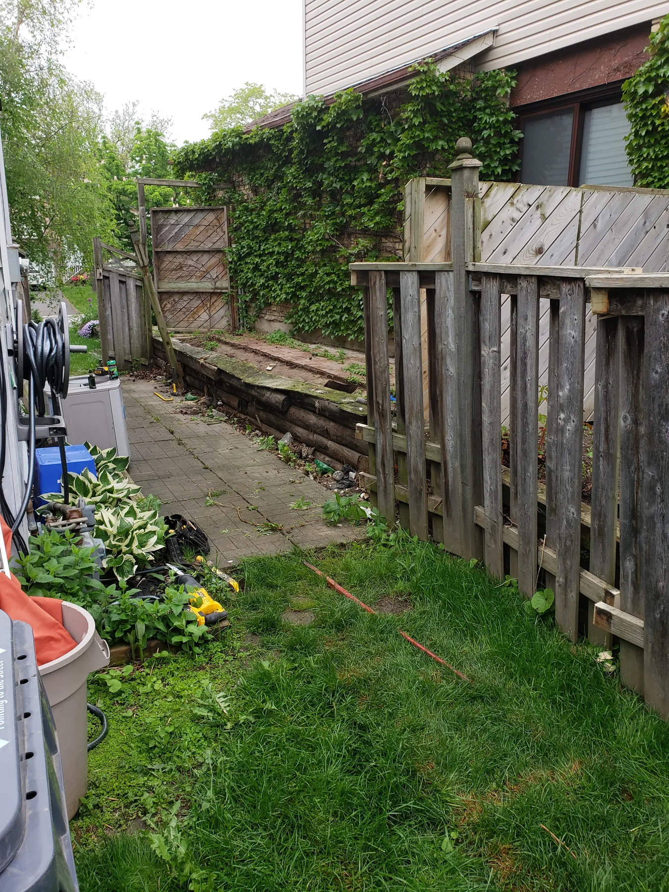Aged and leaning side-yard fence before replacement