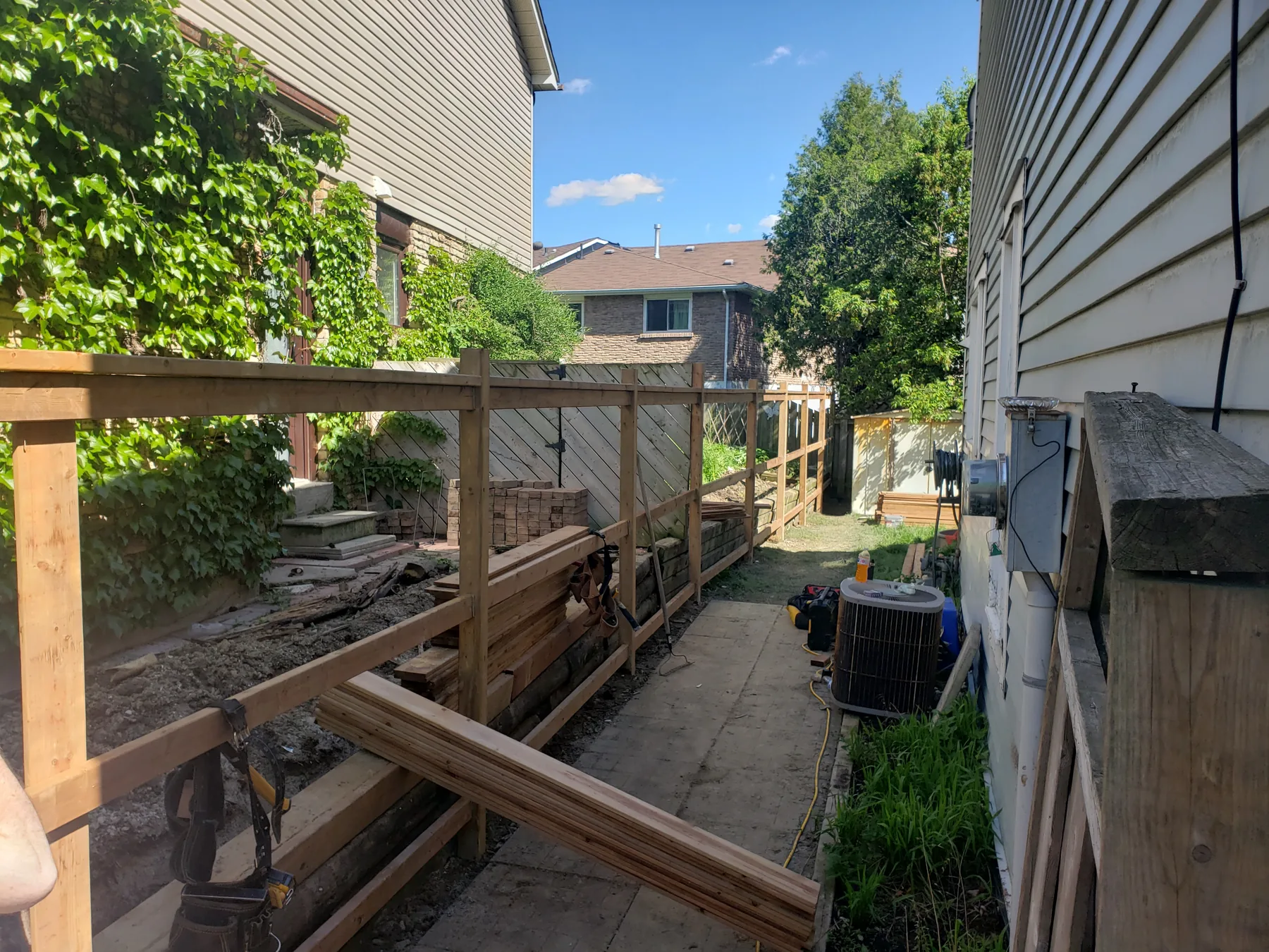 New cedar posts and rails installed beside a narrow walkway