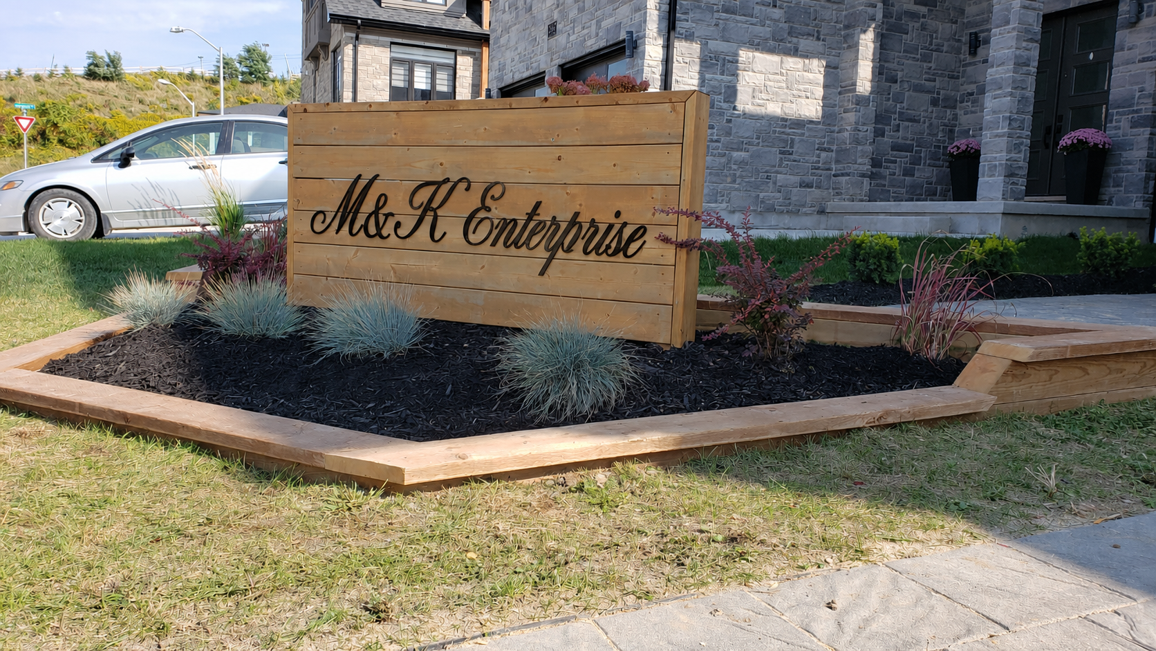 Front view of the flower bed and M&K Enterprise sign
