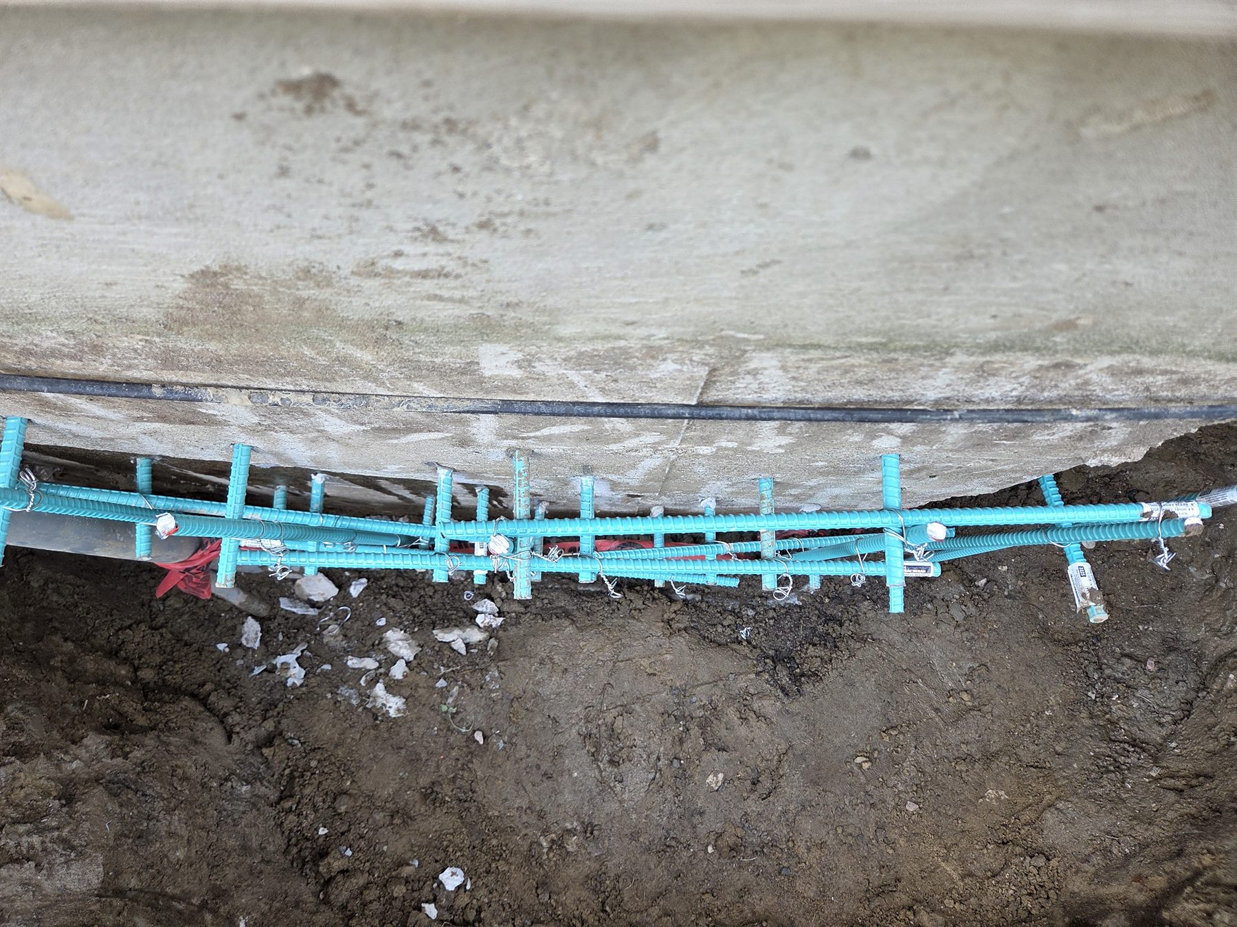 Reinforcement layout prepared along an excavated foundation repair area