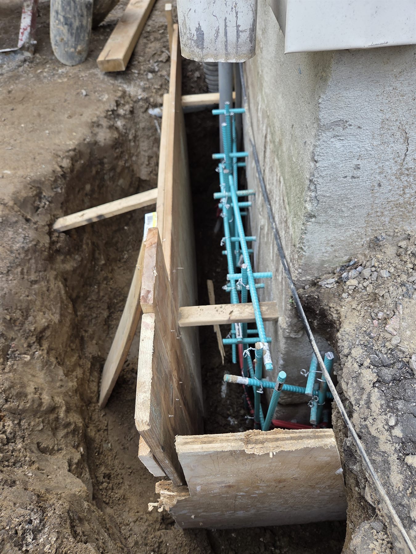 Concrete form and rebar prepared beside the existing foundation
