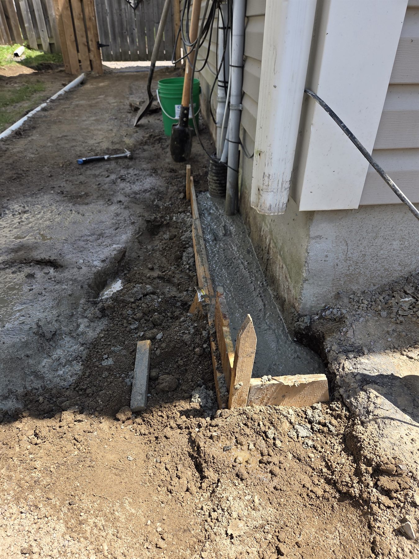 Wide view of concrete placement during exterior foundation repair