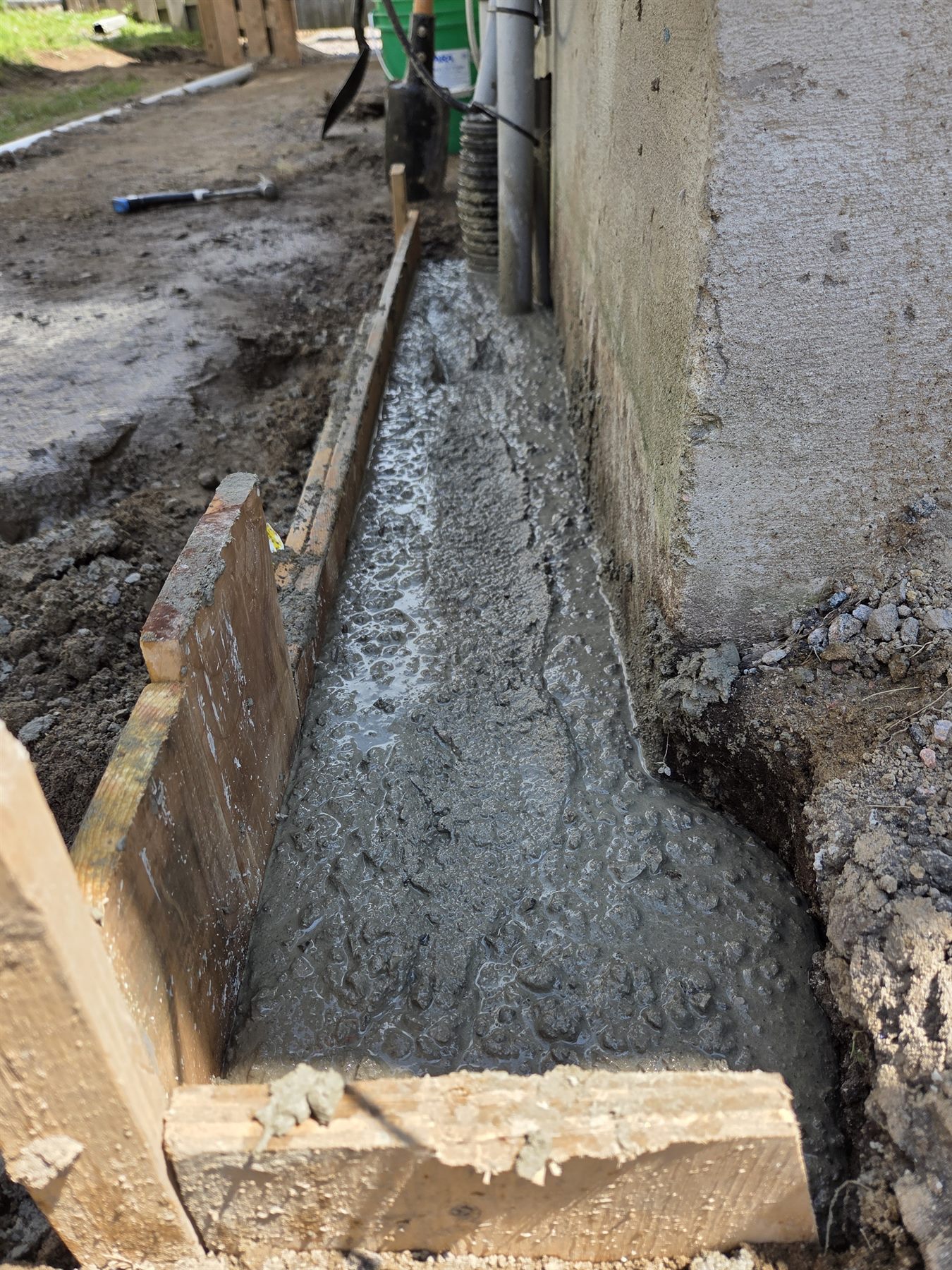 Concrete placed along the exposed foundation repair trench