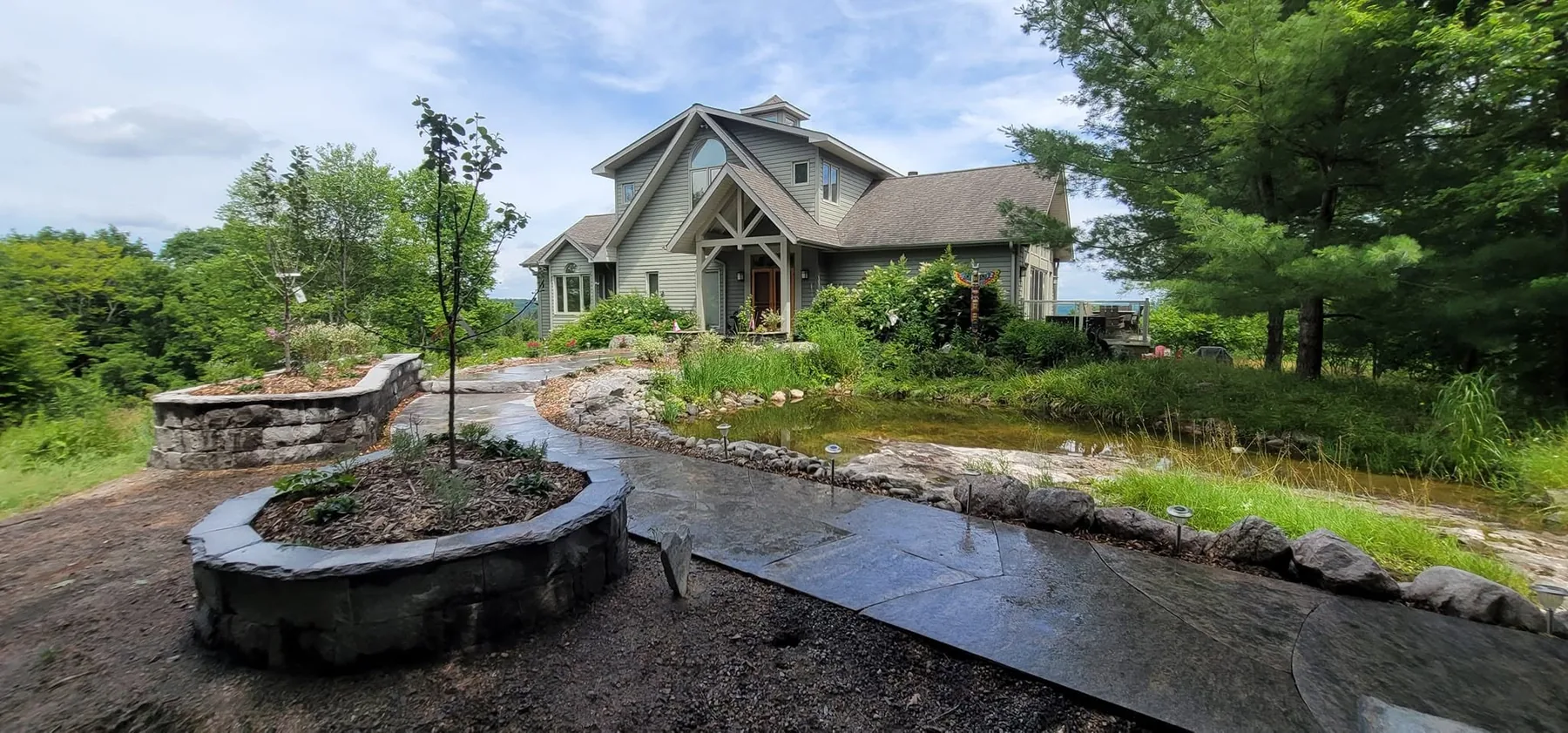 Granite entry stonework panorama with planters, walkway, and stairs