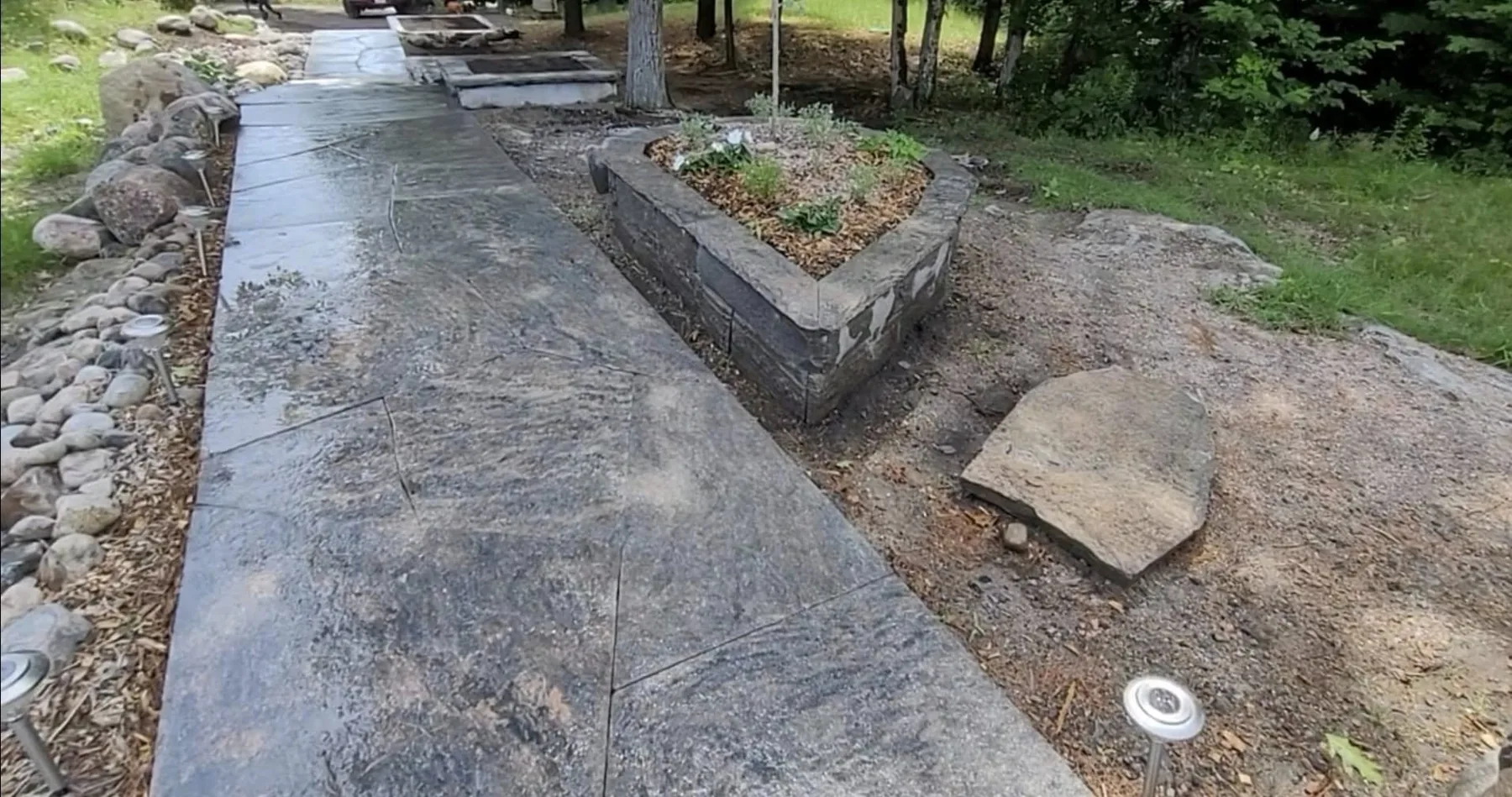 Granite entry walkway beside a low retaining wall