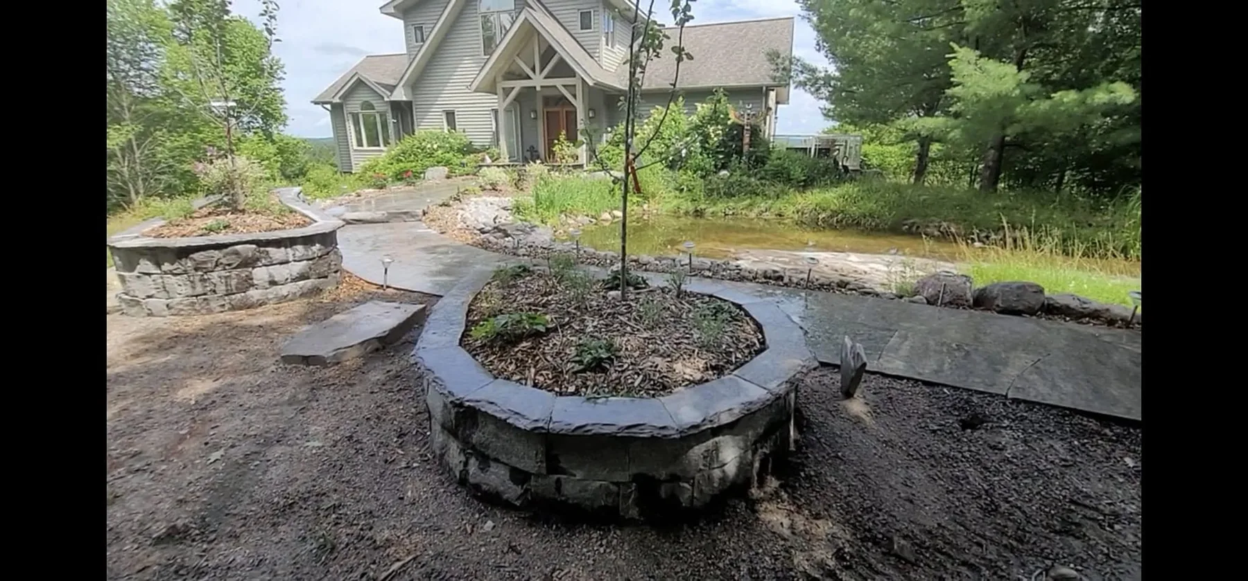 Circular granite planter connected to the entry walkways