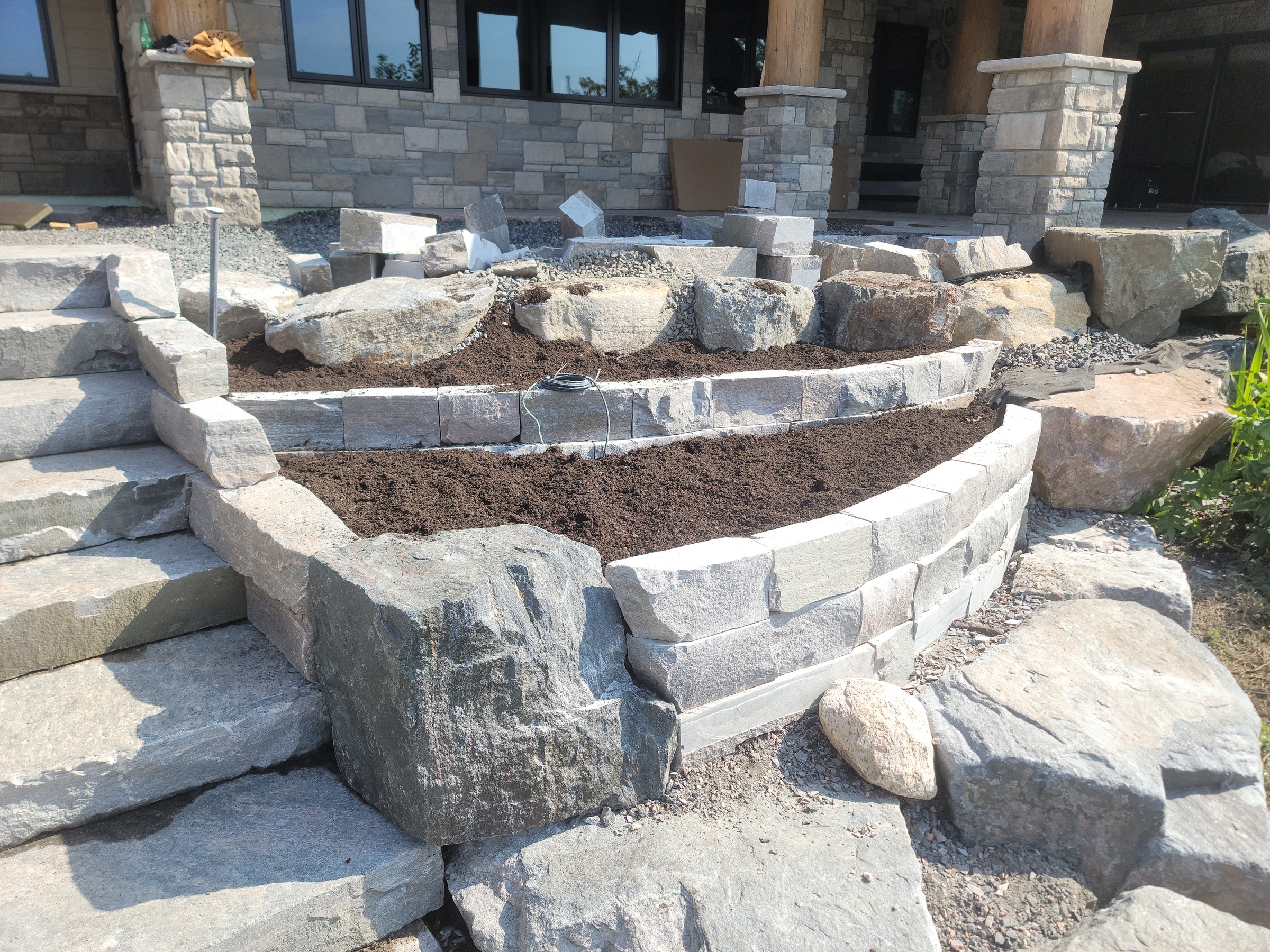Raised stone planter with adjacent finished steps