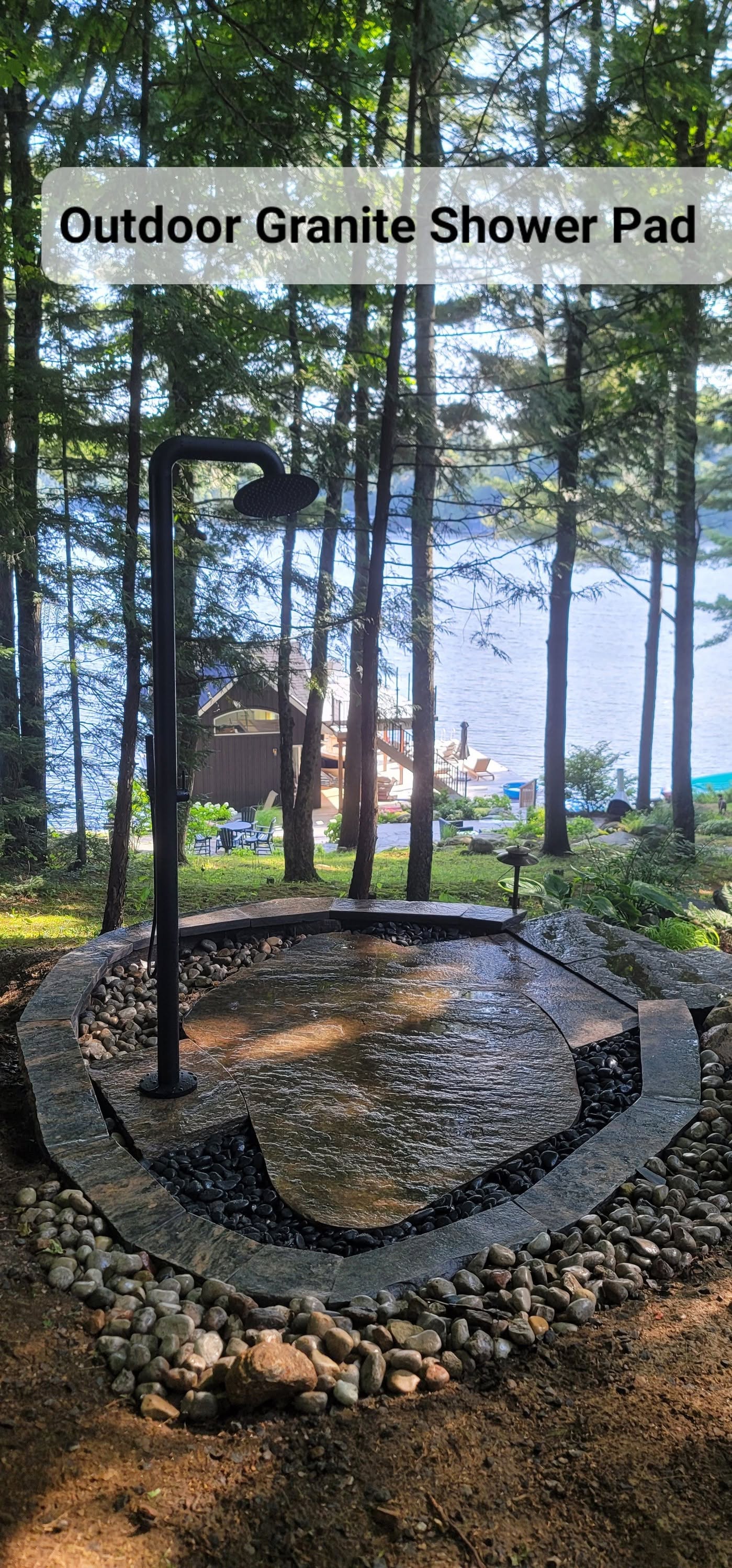 Completed outdoor granite shower beside a lakeside property