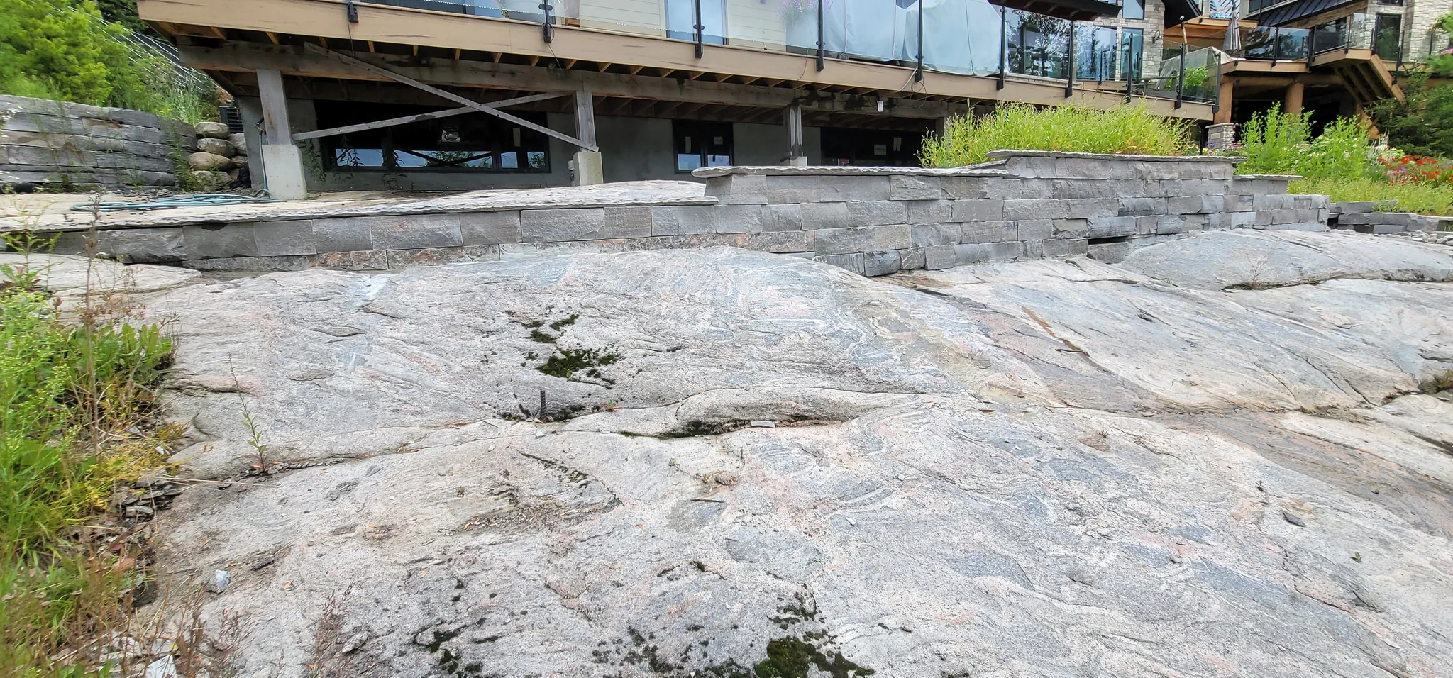 Granite retaining wall built across exposed bald rock below a Muskoka cottage deck