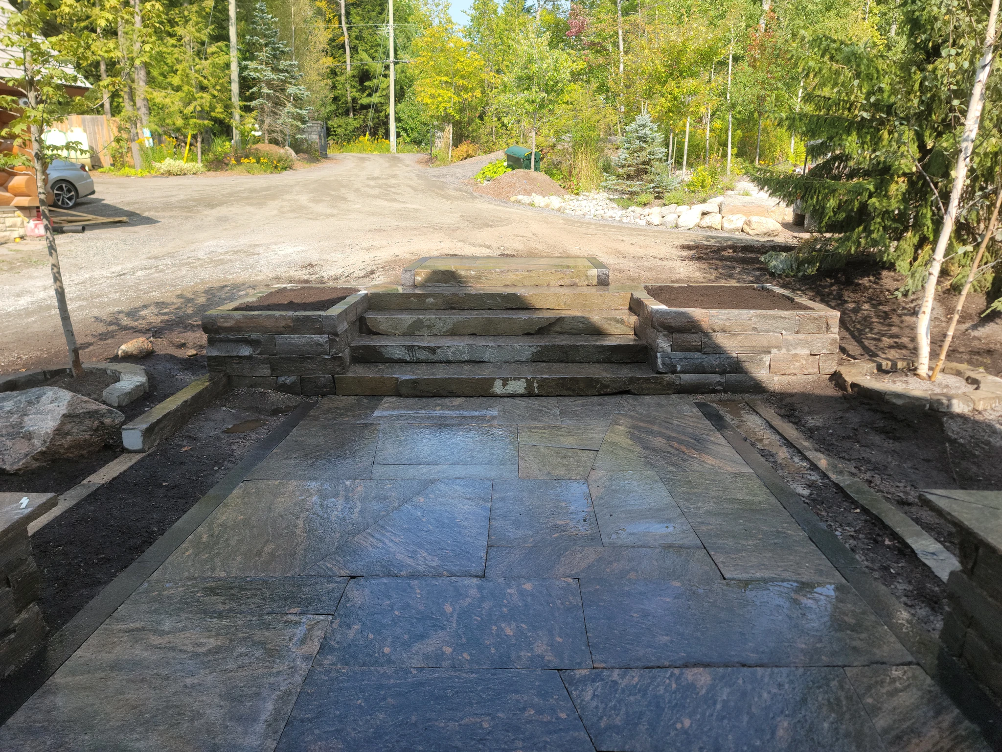 Completed granite steps and raised planters at the front entry