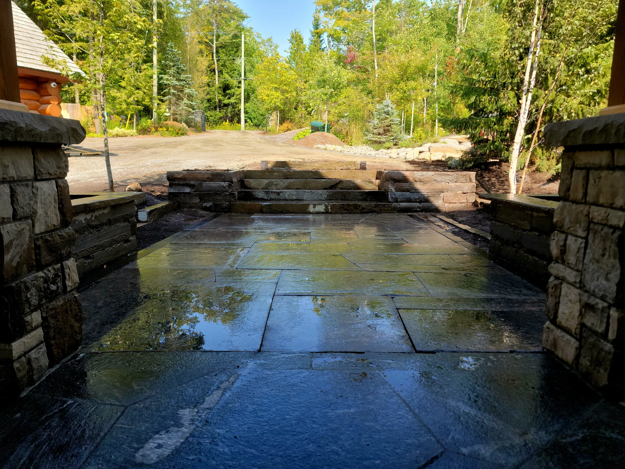 Finished granite entry patio framed by raised planter walls