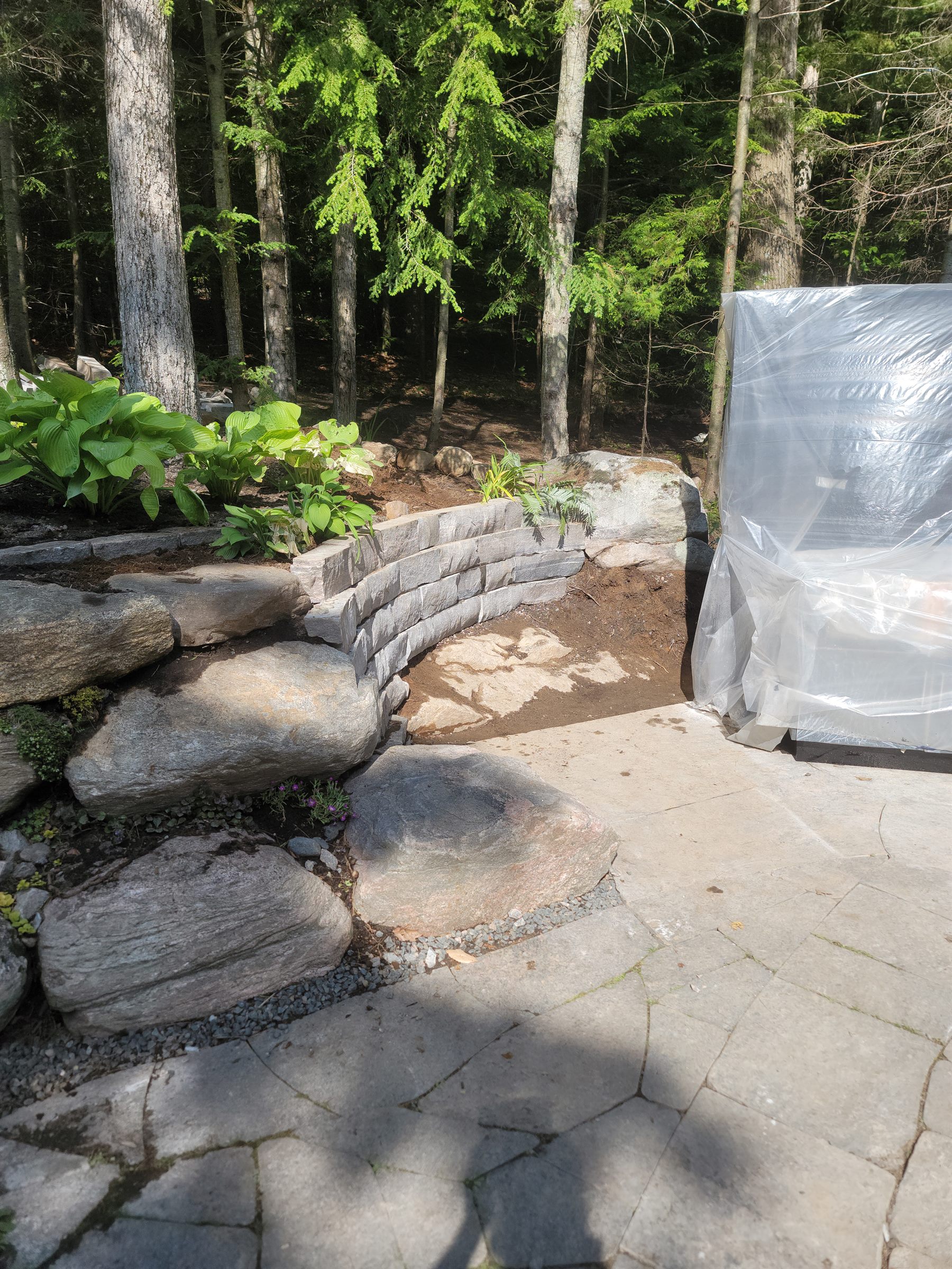 Garden retaining wall site beside a paved patio during preparation