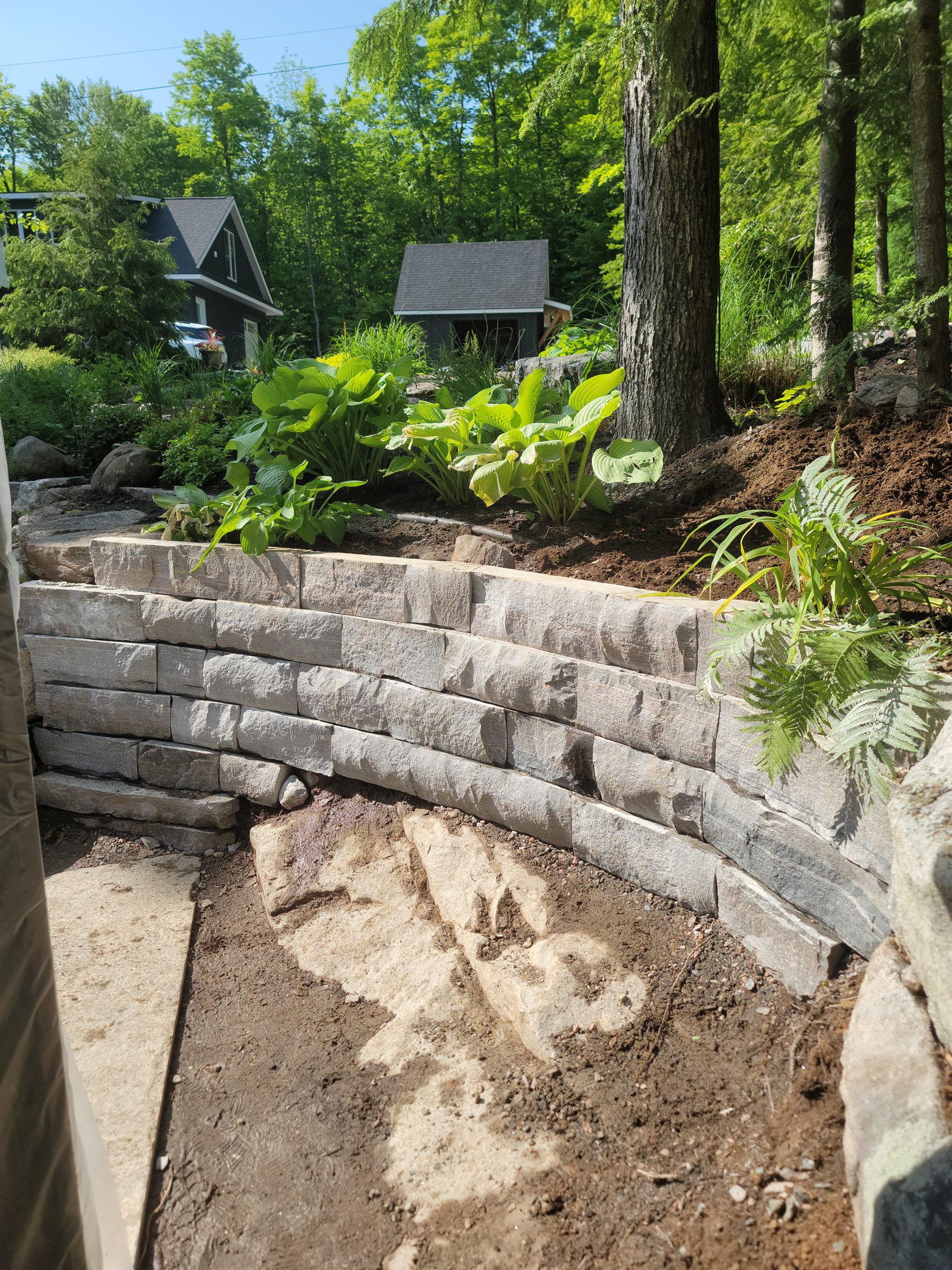 Garden retaining wall progress along the patio edge