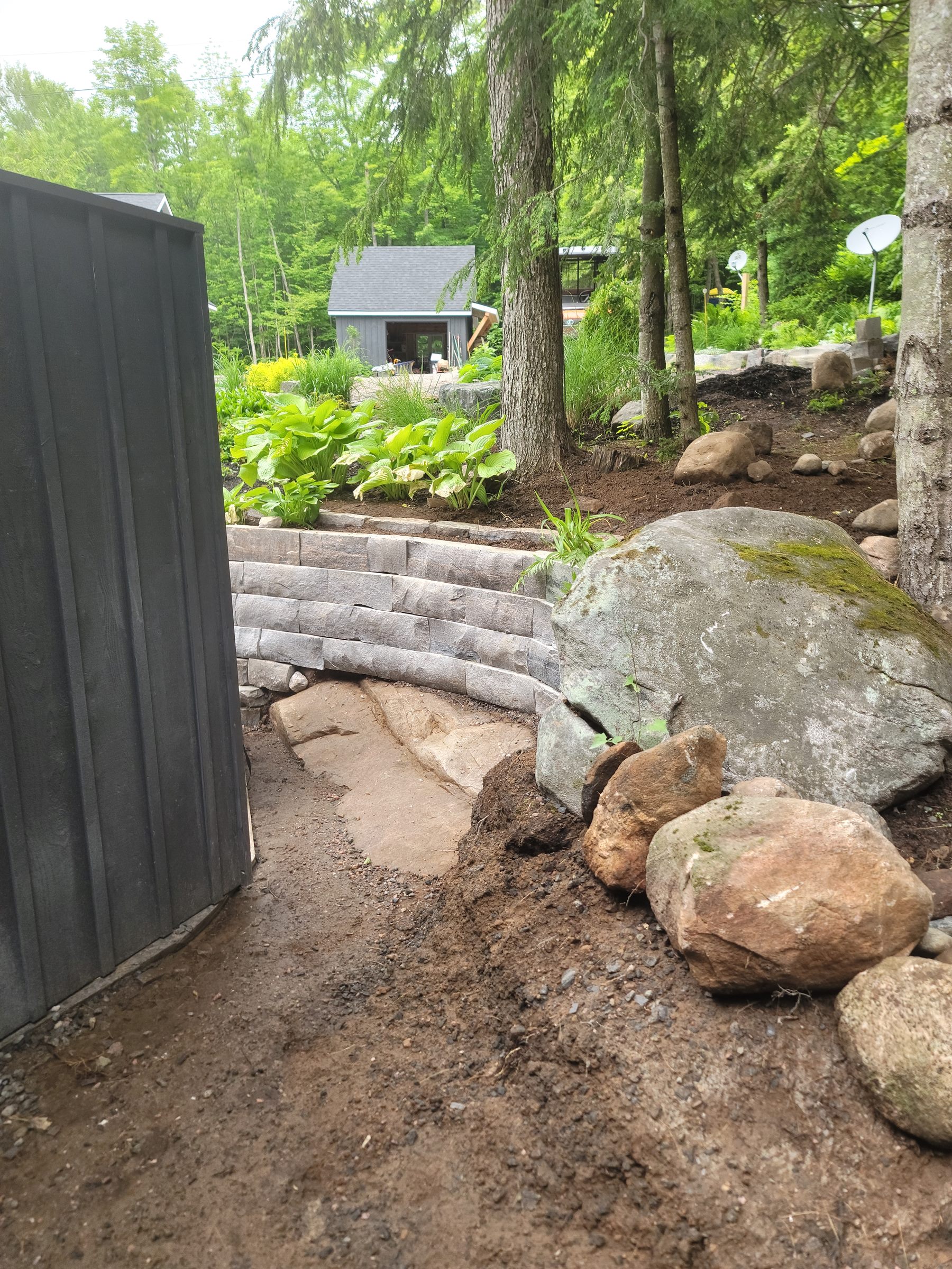 Lower natural-stone garden retaining wall under construction