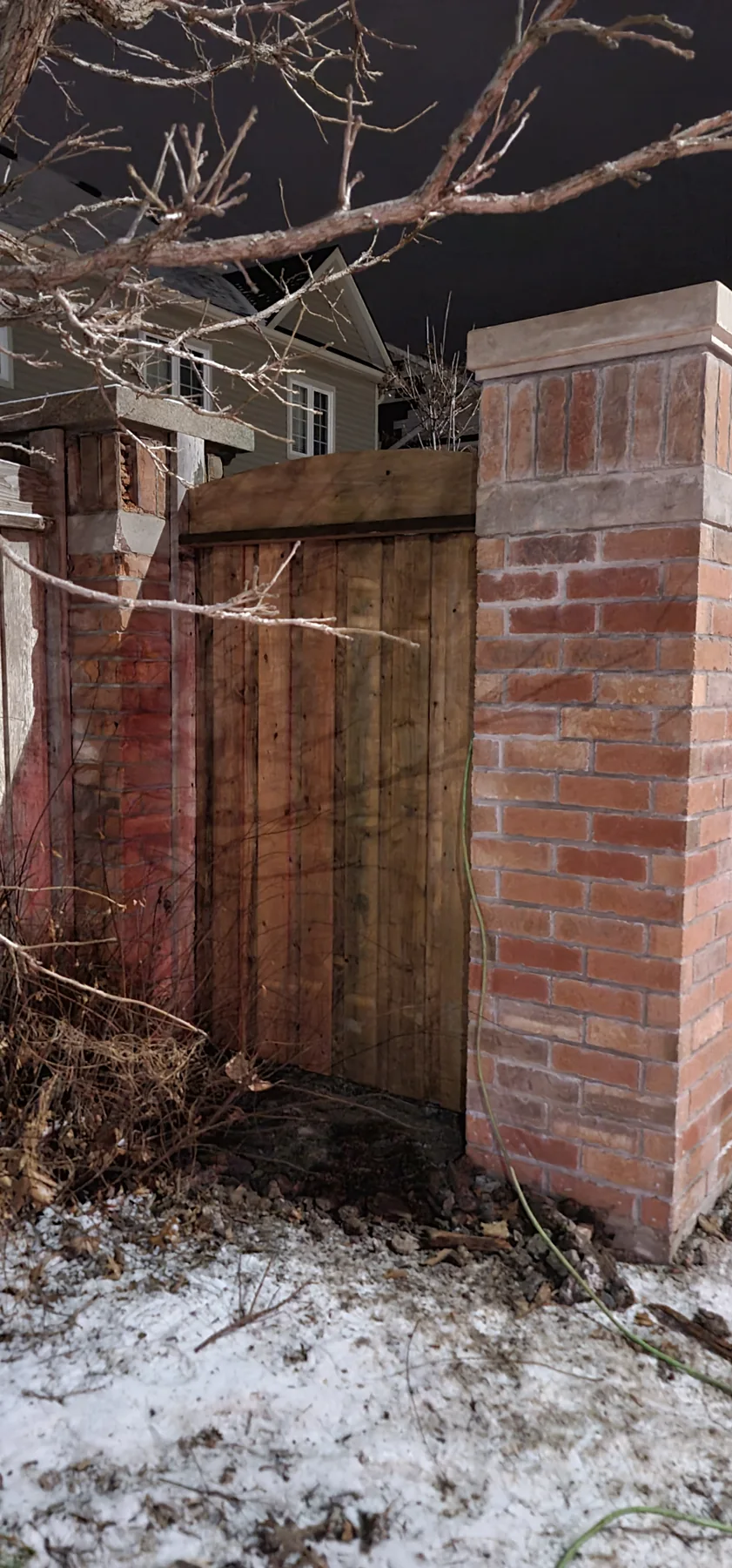 New wood panel fitted between existing brick pillars