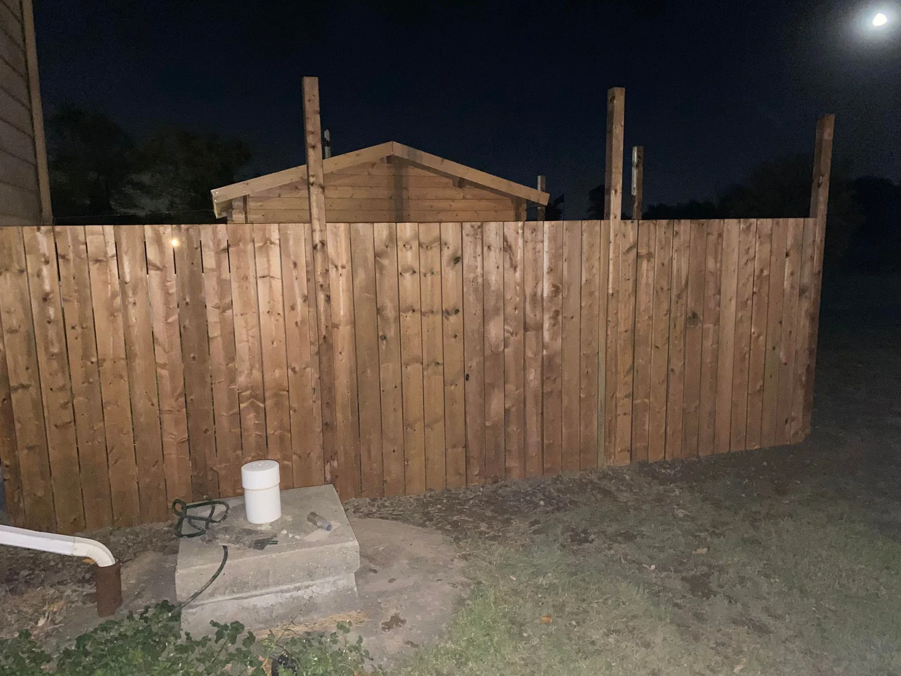 Completed solid-board cedar privacy fence photographed in the evening
