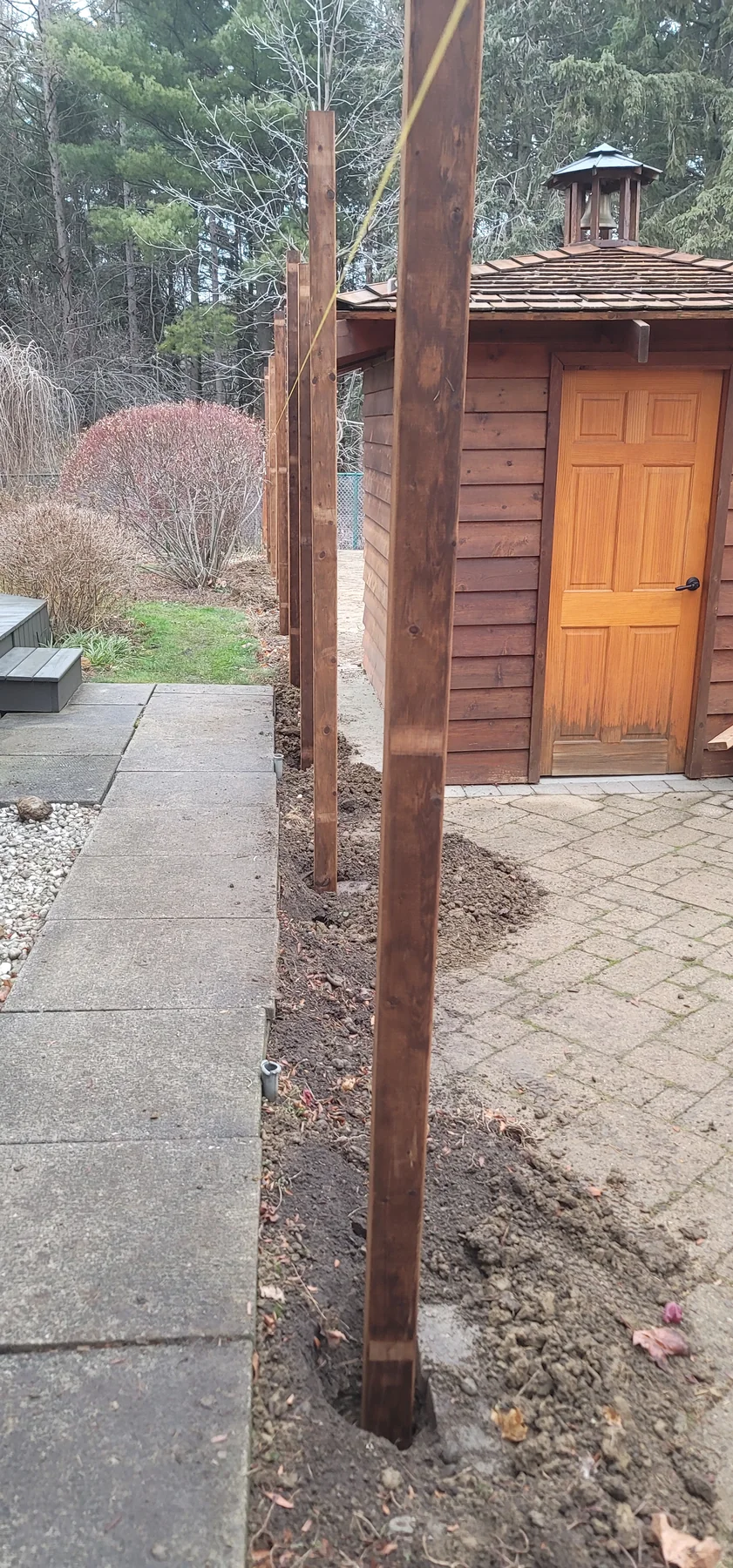 New fence posts aligned around the pool perimeter